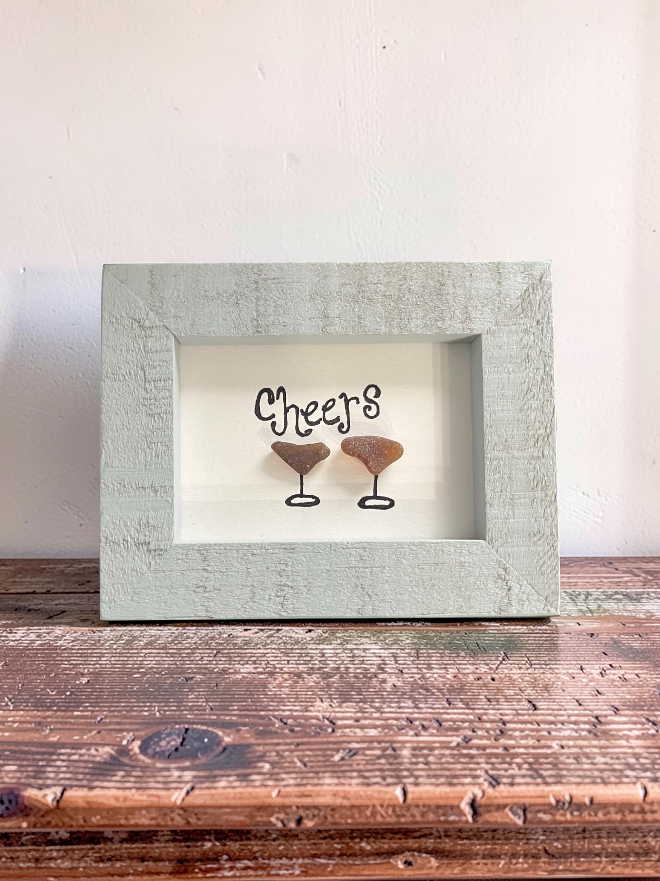 Cheers pebble art with beach stone martini glasses in a sea glass green shadow box frame